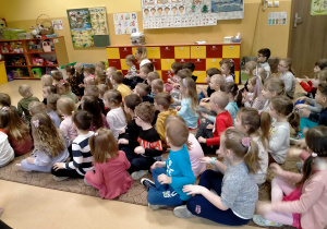 Dzieci siedzą na dywanie i powtarzają ruchy pokazywane przez p.Sylwię i Agnieszkę.ę
