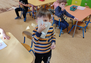 Chłopiec prezentuje sposób wydmuchiwania noska.