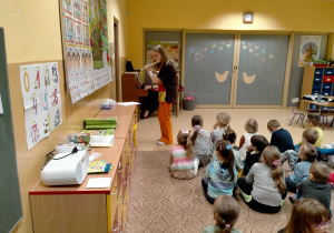 Dzieci słuchają krótkiego koncertu na flecie przy akompaniamencie pianina.
