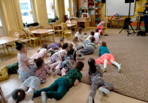 Dzieci przechodzą pod kijkiem " Limbo" zawieszonym między pachołkami.