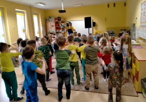 Dzieci z animatorem tańczą przy muzyce.