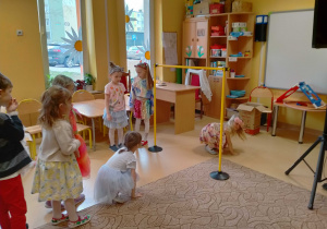 Dzieci przechodzą pod kijkiem "Limbo" umieszczonym miedzy pachołkami.
