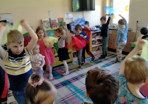 Dzieci tańczą z chusteczkami przy muzyce.
