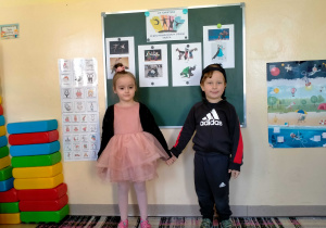 Dziewczynka w stroju baletowym i chłopiec w stroju Hip-Hopowym, stoją w parze