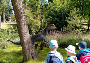Dinozaur wśród drzew i traw.
