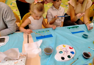 Dzieci malują na szkle.