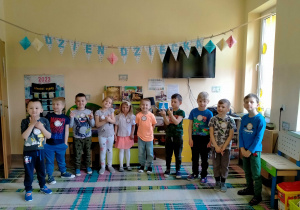 Dzieci stoją pod napisem "Dzień Dziecka"