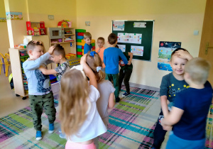 Dzieci tańczą w parach nawzajem trzymając się za głowę.