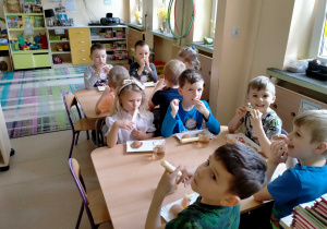Dzieci zjadają słodki poczęstunek.