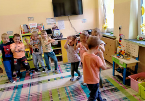 Dzieci graja przy muzyce na wykonanych własnoręcznie "marakasach".