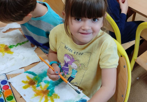 Dziewczynka maluje słoneczniki.