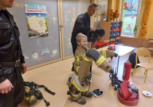 Dziecko przymierza strój strażaka