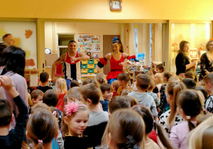 Dzieci tańczą przy muzyce, naśladując ruchy tancerzy.