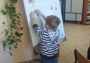 Chłopiec wykonuje zadanie na tablicy