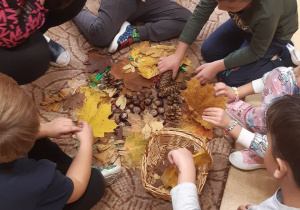 Dzieci pracują z darami jesieni.