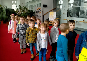 Dzieci stoją w korytarzu teatralnym.