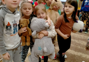 Kilkoro dzieci ze swoimi pluszowymi misiami.