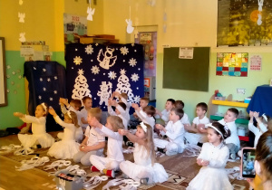 Dzieci śpiewają "anielską" pastorałkę, trzymając w rękach lampioniki.