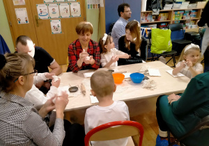 Dzieci ugniatają masę porcelanową.