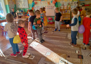 Dzieci tańczą w parach z balonami między pupami.