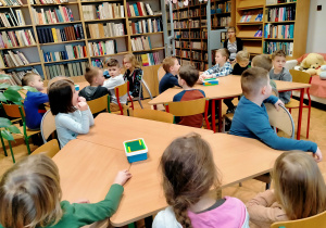Dzieci słuchają bajki czytanej przez p. bibliotekarkę.