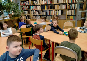 Dzieci słuchają bajki czytanej przez p. bibliotekarkę.