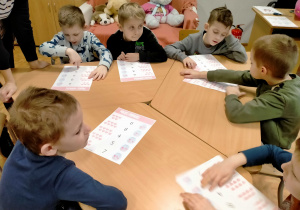 Dzieci wykonują matematyczne karty pracy o tematyce walentynkowej.