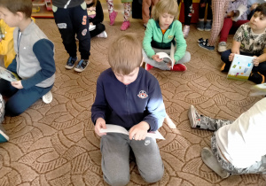 Chłopcy oglądają otrzymane książki.