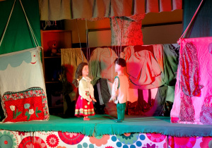 Na scenie występują marionetki Emilki i Romusia.