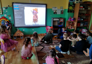 Dzieci oglądają lalki teatralne w wirtualnym muzeum lalkarstawa w Słupsku.