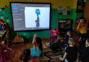 Dzieci oglądają lalki teatralne w wirtualnym muzeum lalkarstawa w Słupsku.