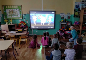 Dzieci oglądają film dydaktyczny pt.: "Nie tańcz z wilkami", poruszający problem wstawiania zdjęć i filmów w internecie.