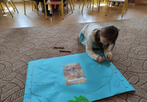 Dziewczynka maluje drzewa.