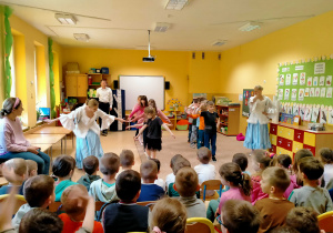 Tancerki uczą dzieci kroków Poloneza.