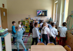 Dzieci tańczą przy muzyce granej na bandżo.