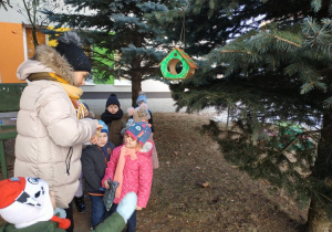 Dzieci powiesiły karmnik dla ptaków.