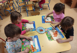 Dzieci malują elementy karmnika.