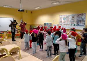 Dzieci w czapkach krasnali na głowach, tańczą z p. Ulą.