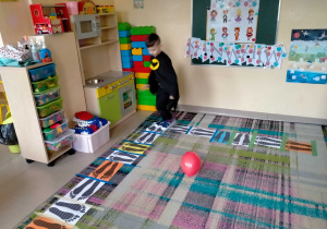 Chłopiec porusza się przy muzyce po "śladach" na dywanie.