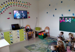Dzieci słuchają jak p. Armen gra na tradycyjnym bębnie.