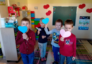 Chłopcy pokazują serca w kolorze niebieskim i różowym, tworząc pary.