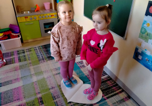 Dziewczynki stoją na dużym papierowym sercu.