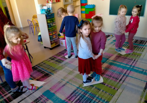 Dzieci tańczą w parach na dużych papierowych sercach.
