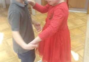Chłopiec tańczy z dziewczynką na gazecie
